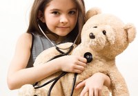 Kind Hört mit einem Stetoskop die Brust ihres Bären ab. Link zu Erster Hilfe am Kind.